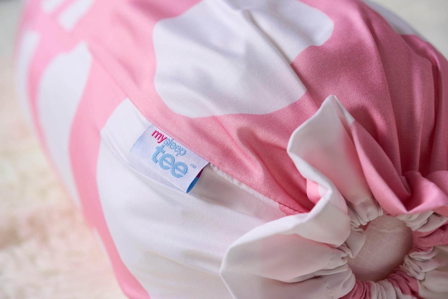 Pink and white bolster with a visible brand label on a soft background by MySleepTee