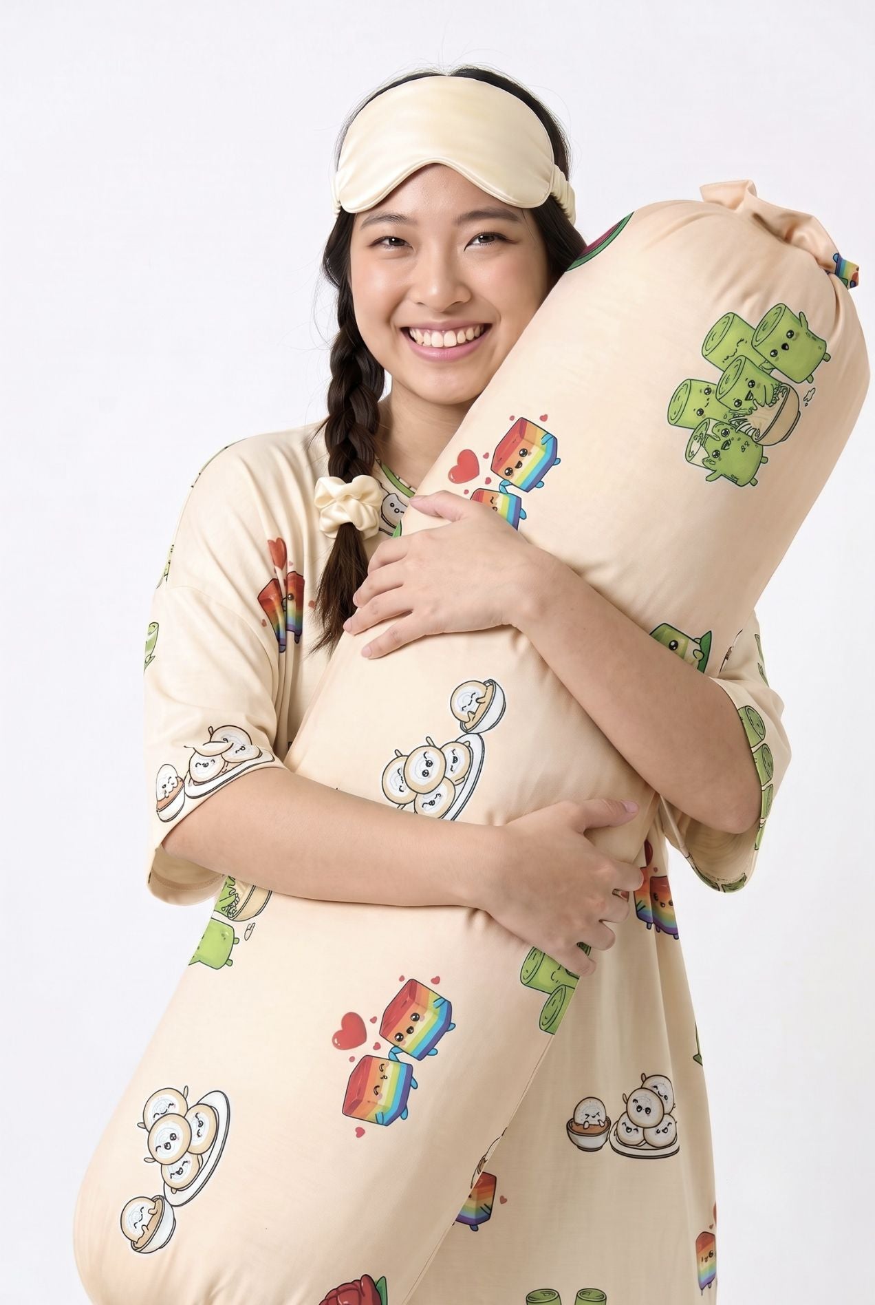 Woman in Kueh-zy Medley cream kueh print sleep tee hugging a matching bamboo bolster