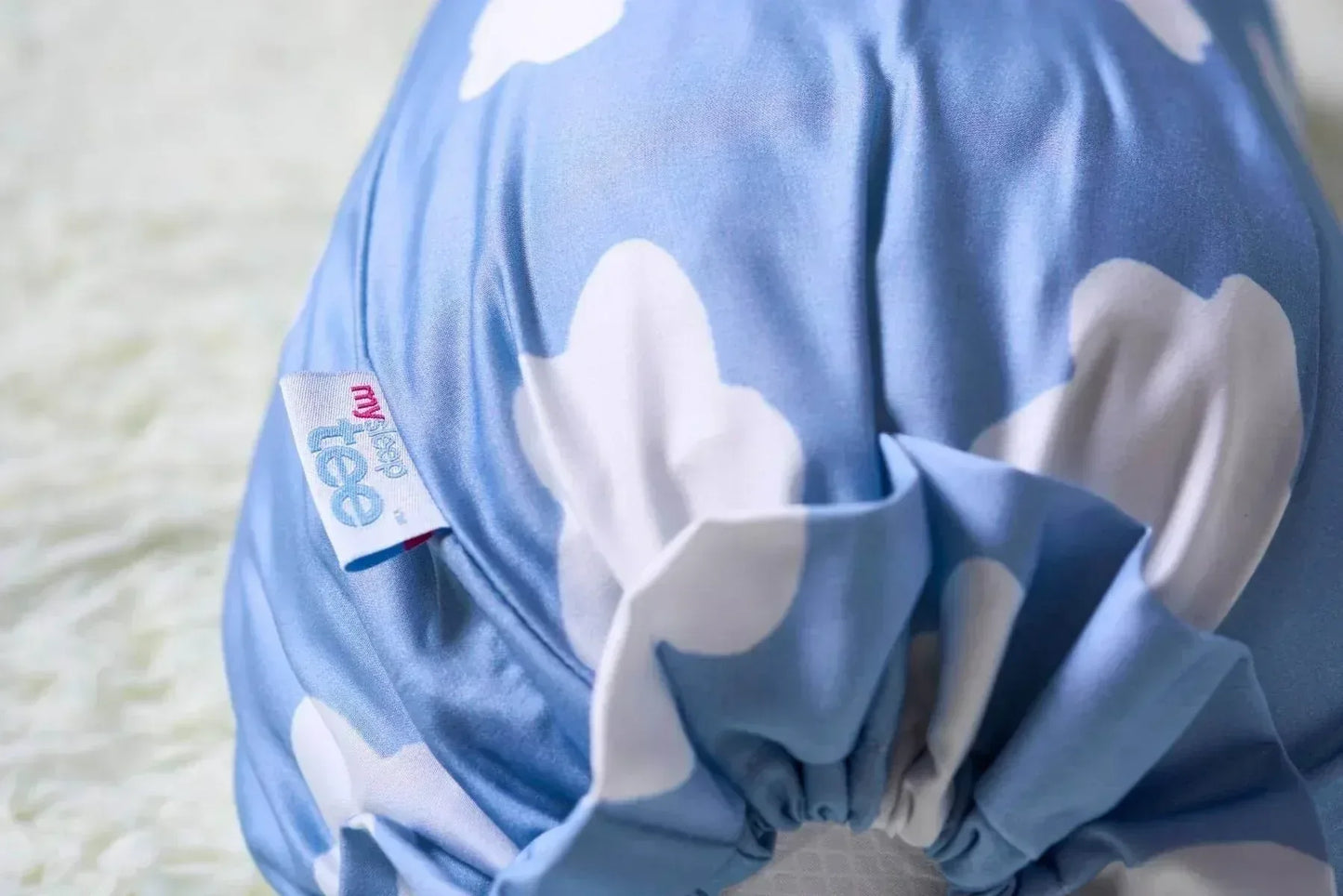 Blue bolster with white cloud patterns on a light background