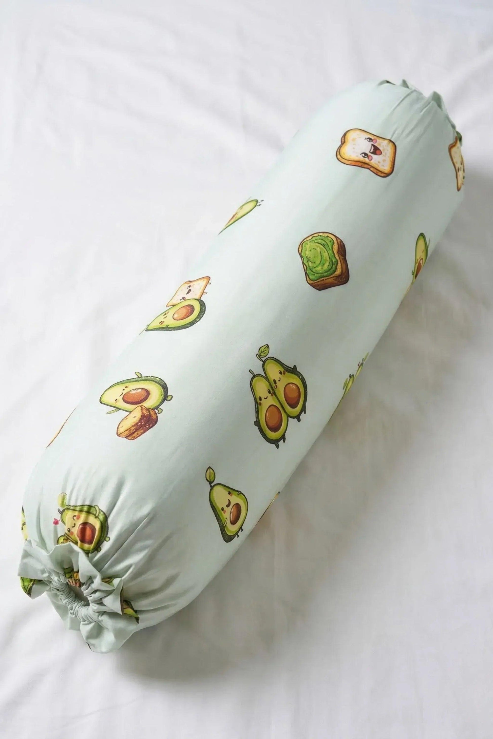 A full-length, top-down view of the Avo-Good Night bolster cover featuring a cute avocado and toast pattern on a mint green background.