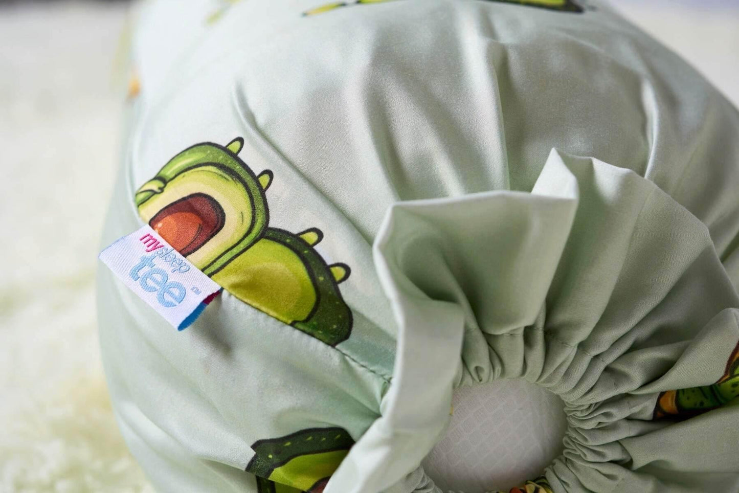 Light green bolster with cartoon avocado design and 'mysleeptee' tag on a white background