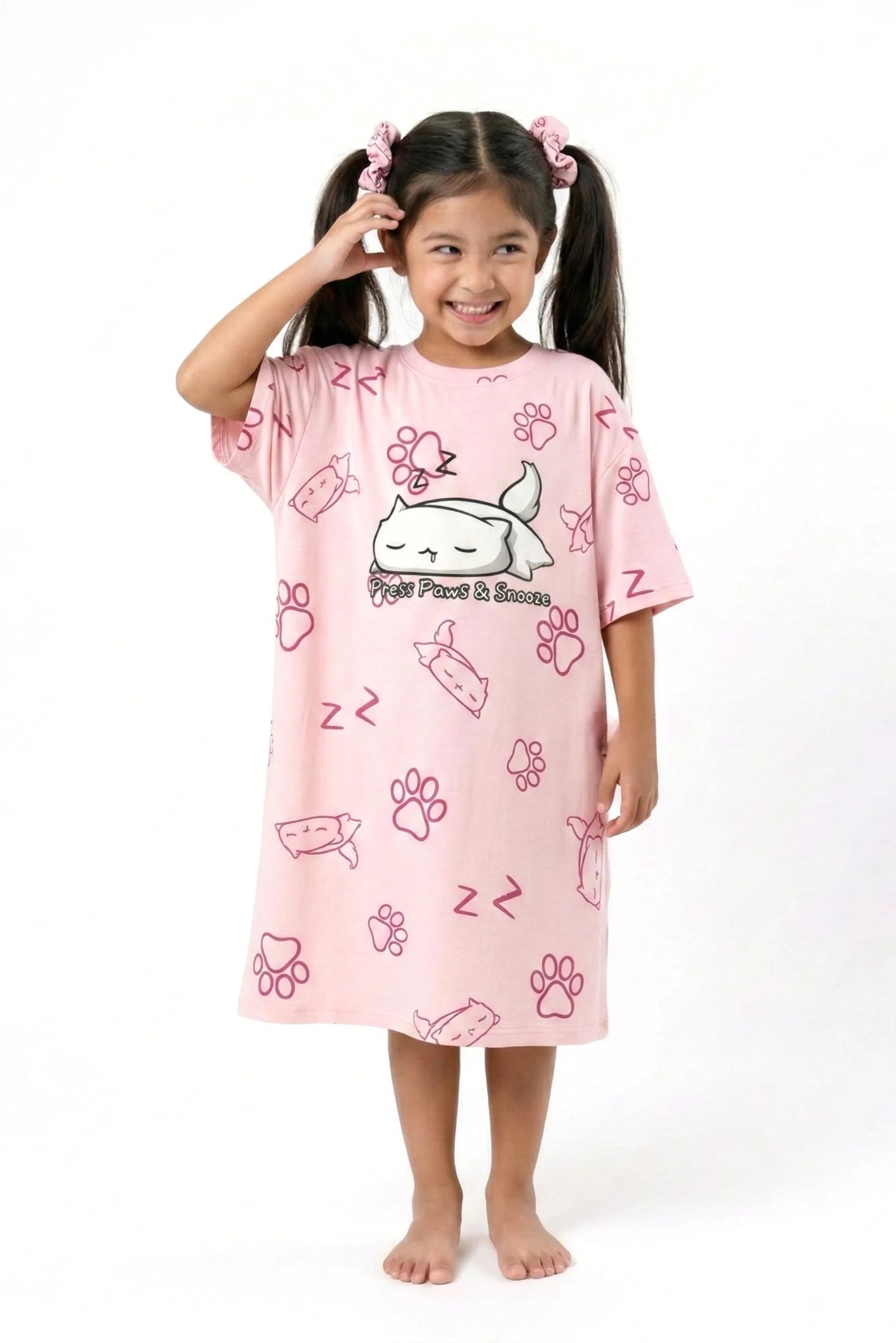 A cute girl wearing a pink "Paws & Snooze" bamboo sleep tee, showcasing the soft and stretchy fabric for children.