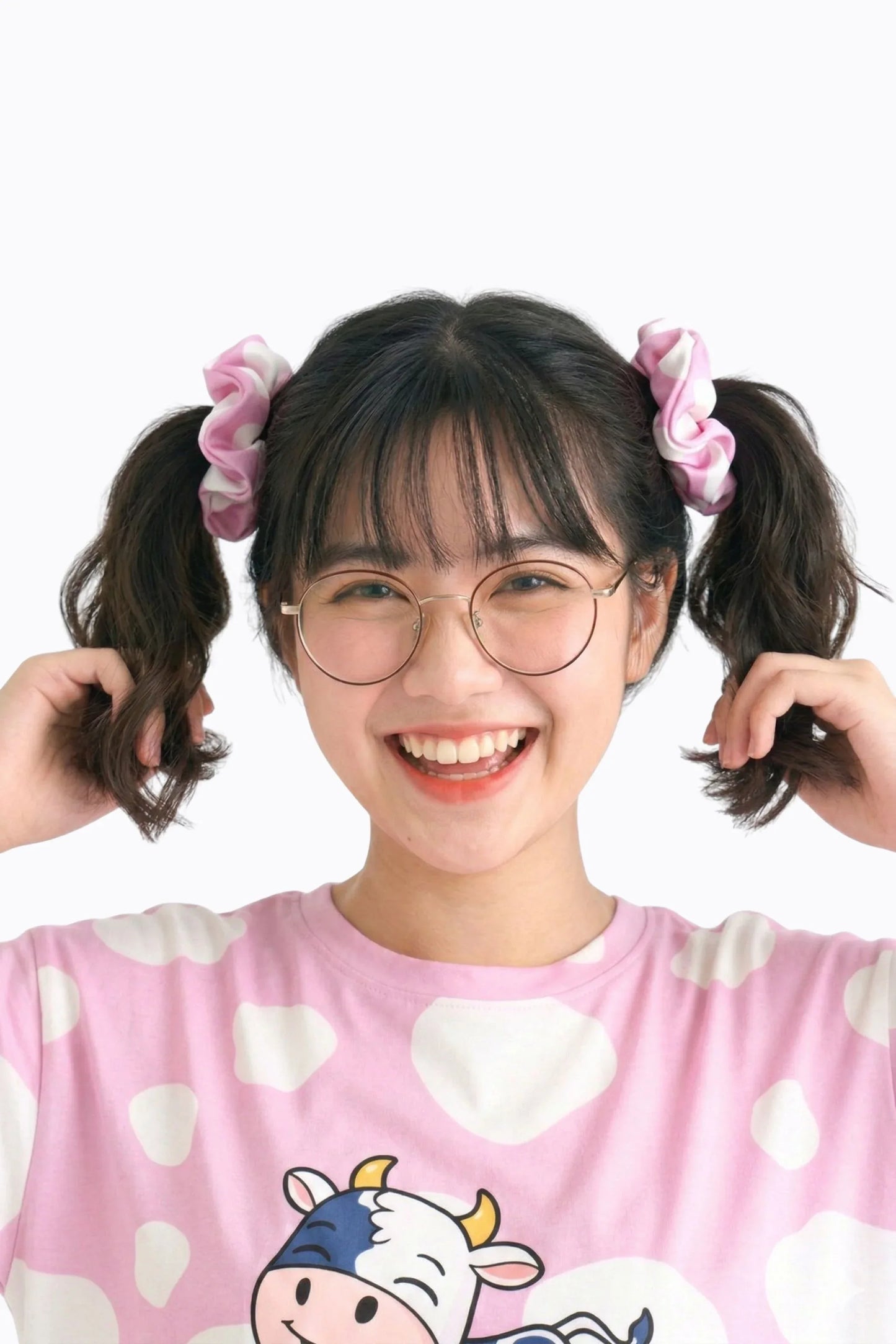 Woman wearing pink cow print bamboo scrunchies in pigtails with matching Moo-nlight bamboo sleep tee