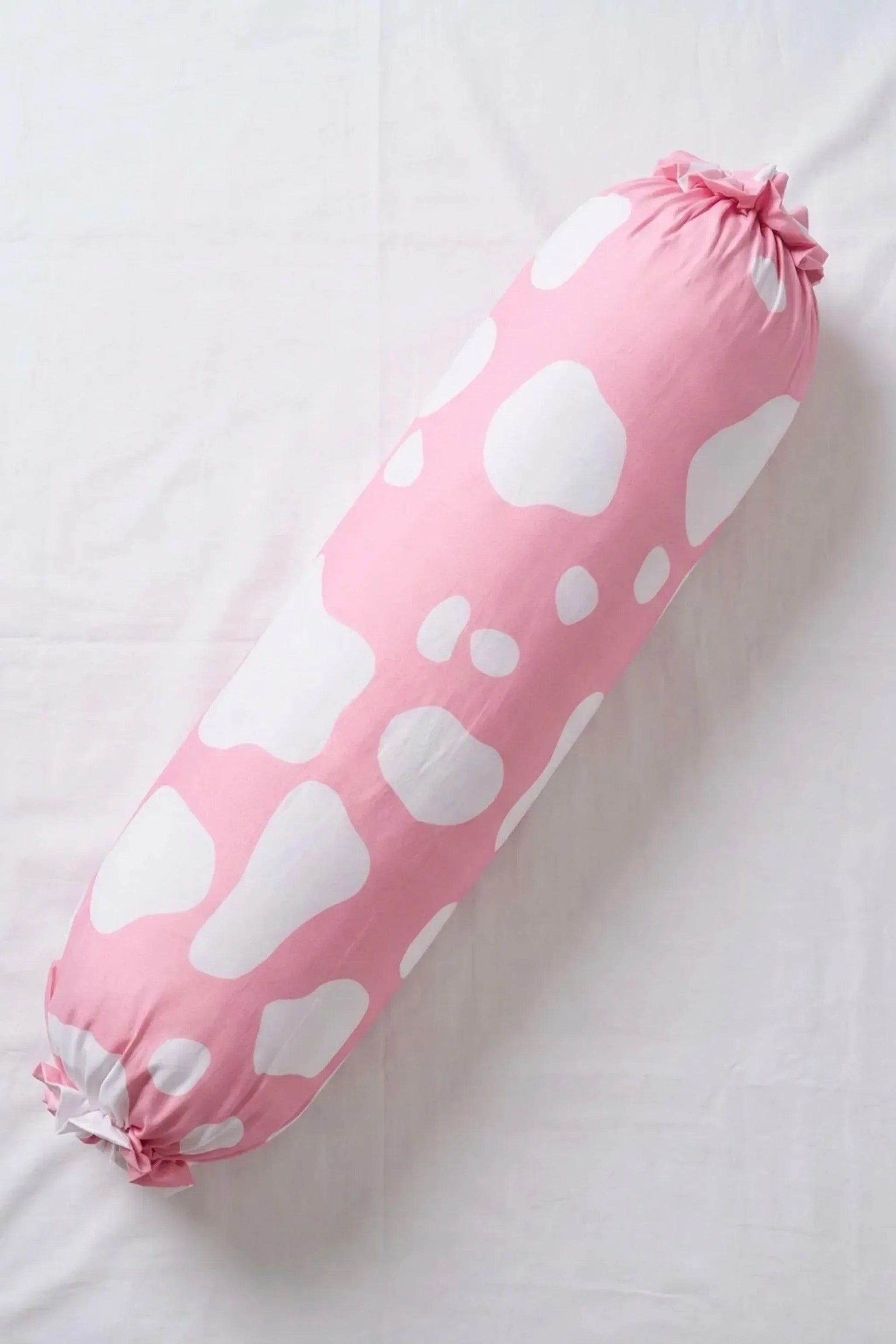 A full-length, top-down view of the pink cow print bolster pillowcase laid flat on a white surface.