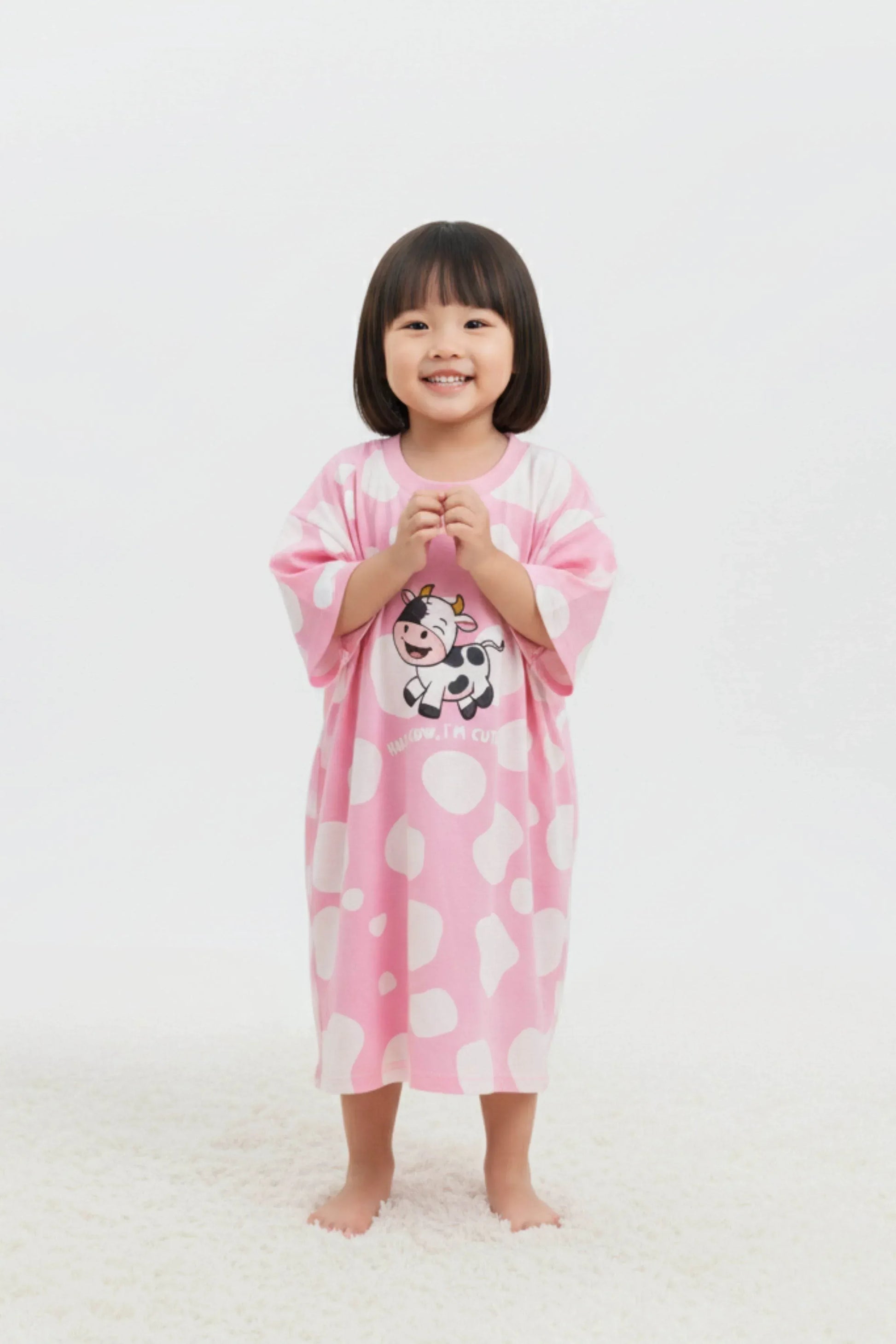 Child wearing a pink cartoon character oversized bamboo sleep tee on a white background
