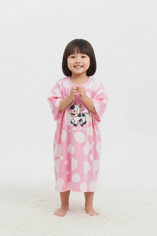 Child wearing a pink cartoon character oversized bamboo sleep tee on a white background