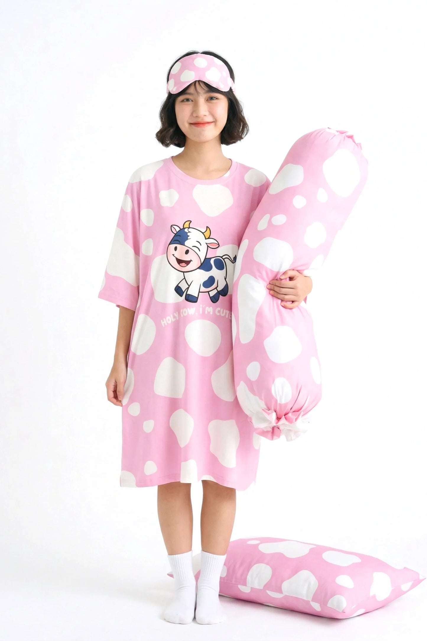 Woman wearing full Moo-nlight bamboo sleepwear set including sleep tee sleep mask bolster cover and pillow case in pink cow print