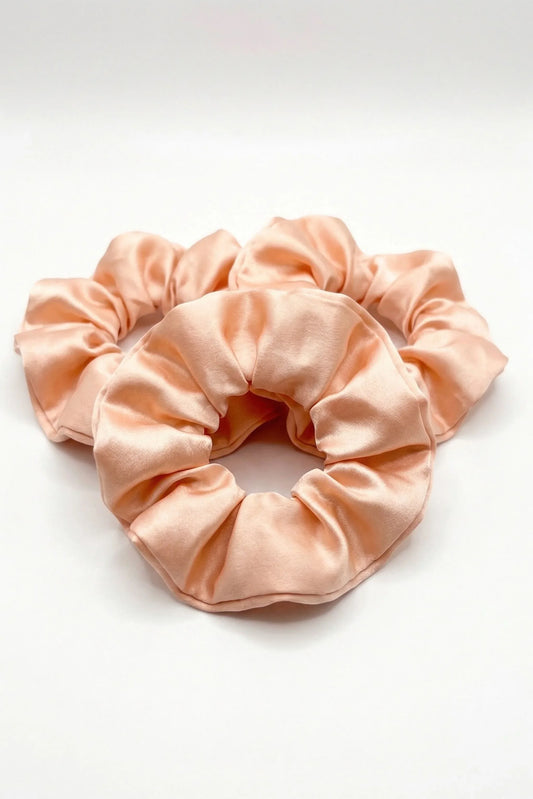 Salmon pink bamboo scrunchies with silky satin finish on white background