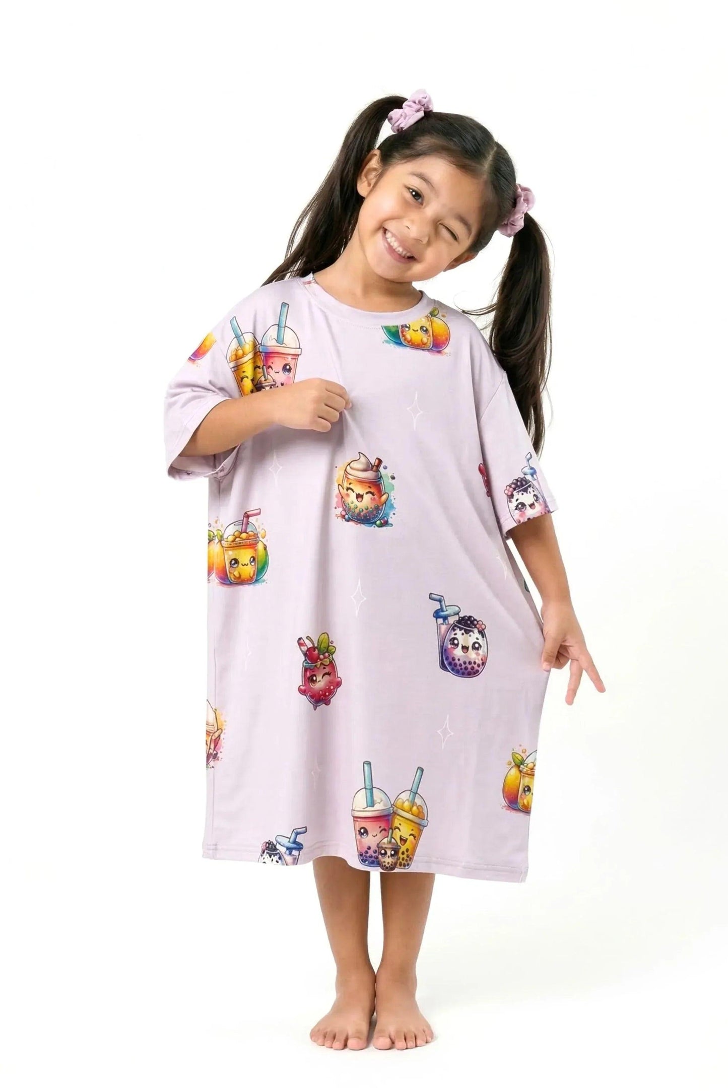 A cute girl with pigtails playfully tilting her head and smiling while lightly pinching the stretchy, soft fabric of her light purple MySleepTee™ The Bubble Tee | Kids sleep shirt.