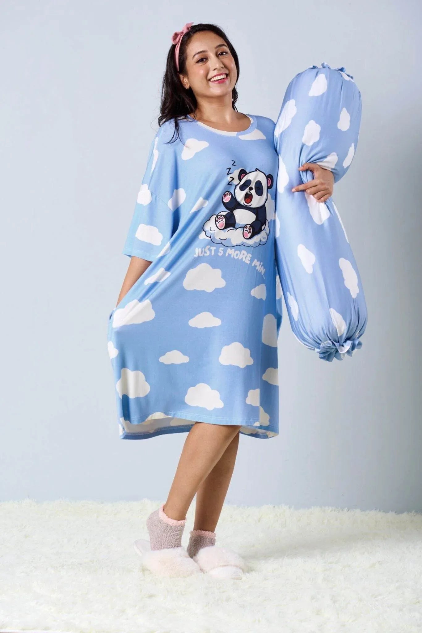 Woman wearing oversized sleep tee from MySleepTee and is holding a blue bolster with cloud and panda 