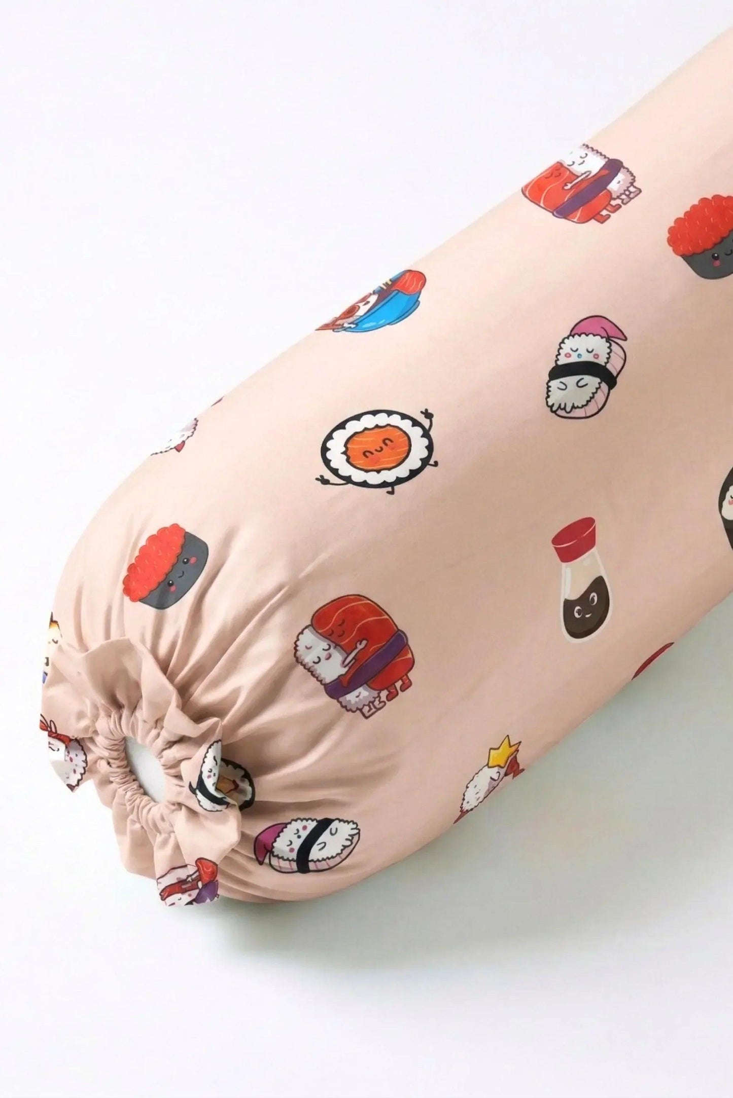 A close-up angled view of the Soy Cozy bolster cover featuring adorable sushi and soy sauce bottle characters on a soft beige background.
