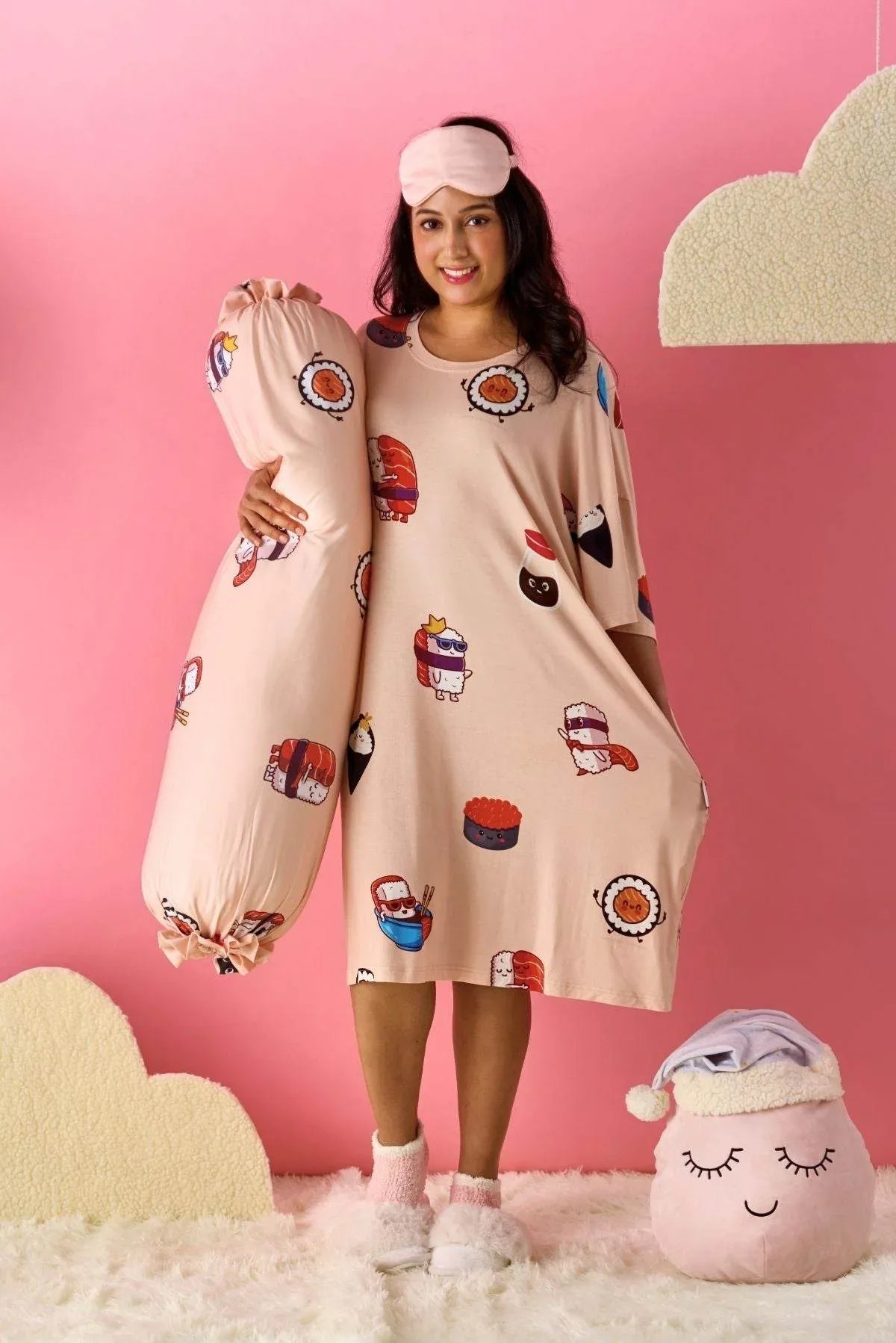 Woman wearing a patterned nightshirt with a pink background and cloud decorations.