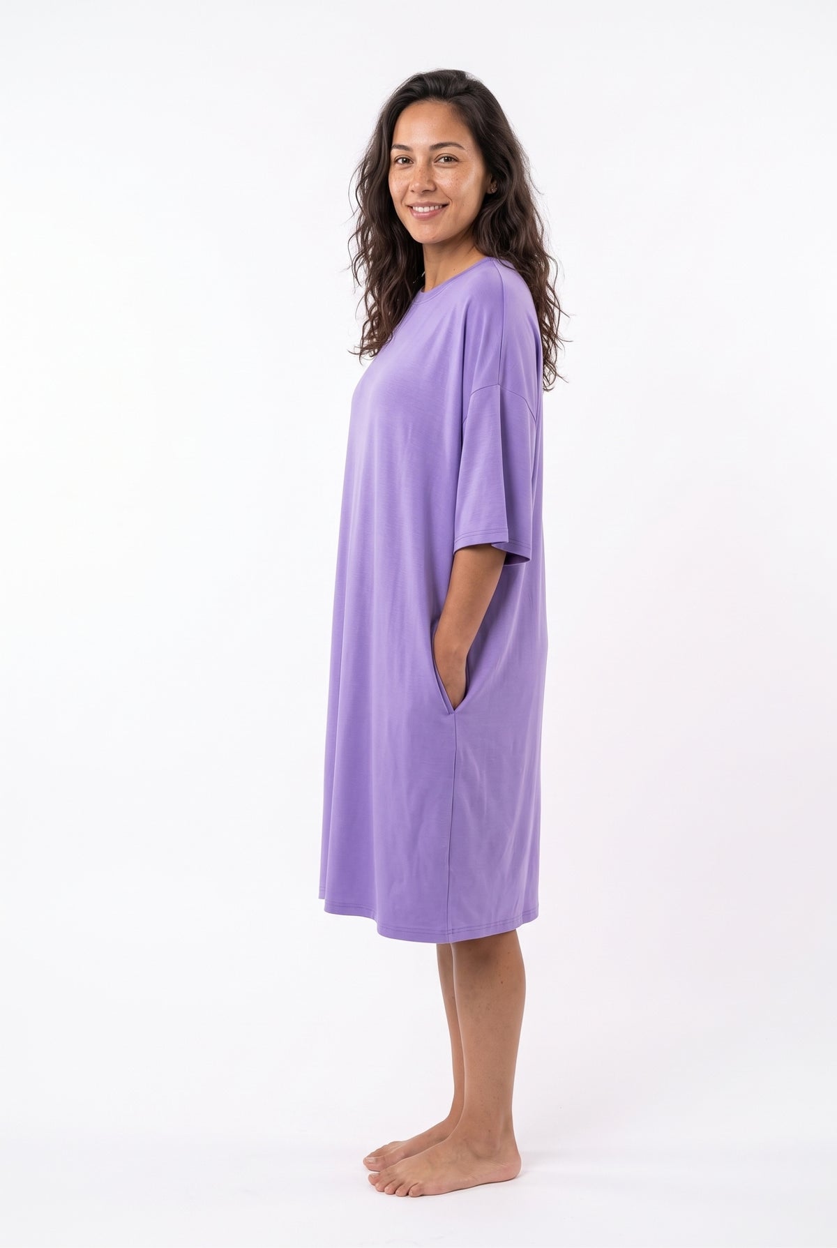 Lilac purple bamboo oversized sleep tee, side view with hand in the hidden side pocket, showing the long nightdress length and soft cocoon fit