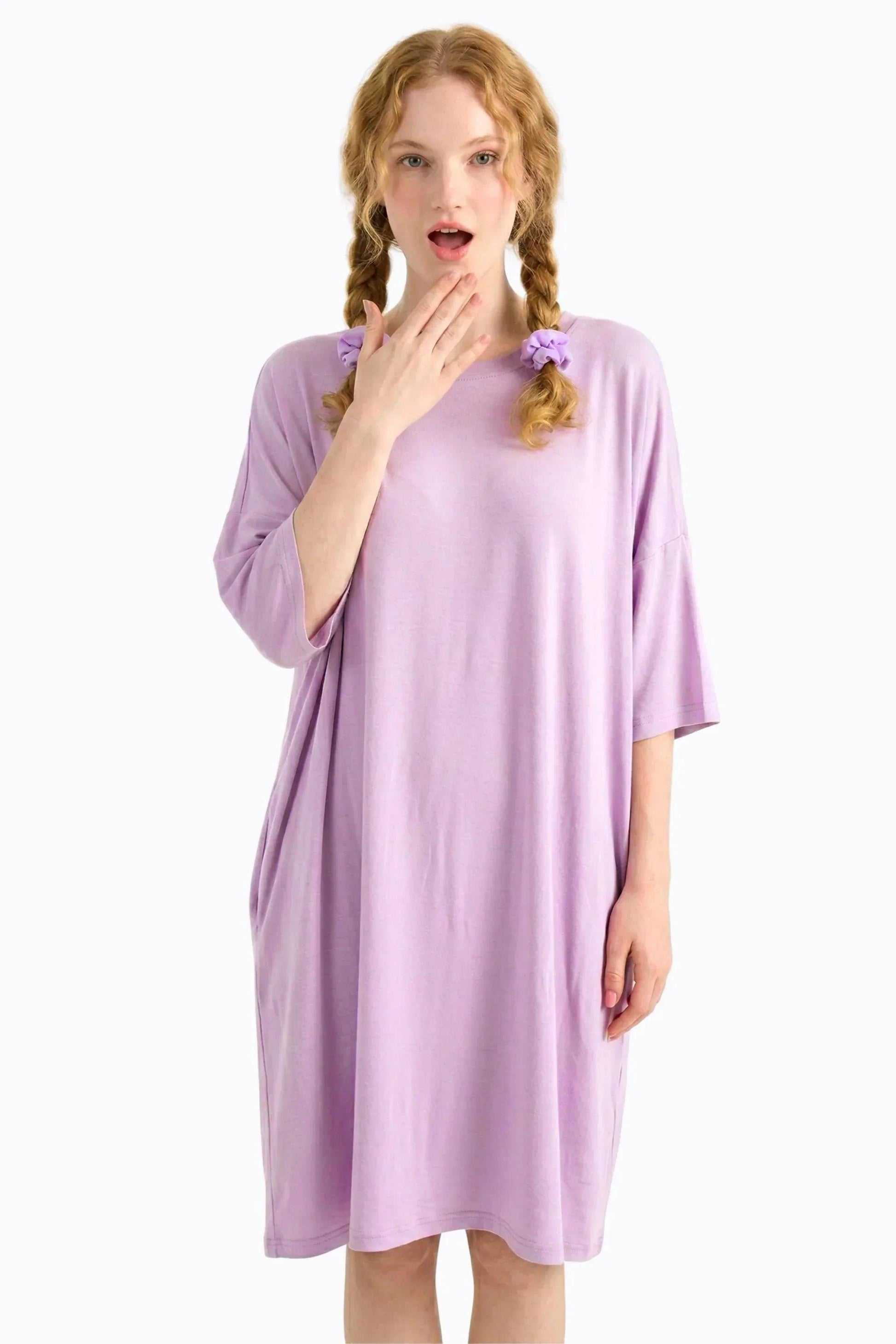 Woman wearing a purple nightgown on a white background