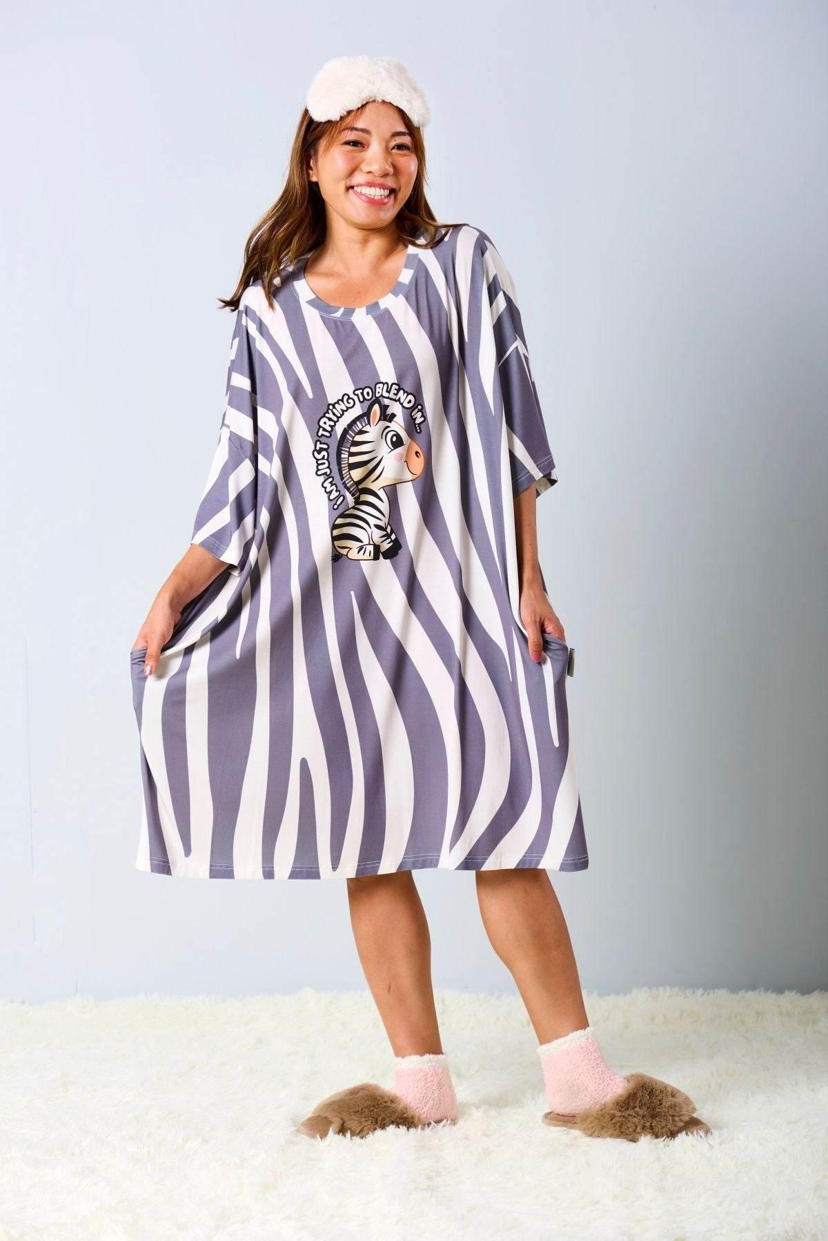 Woman wearing a striped nightshirt with a zebra design on a light gray background