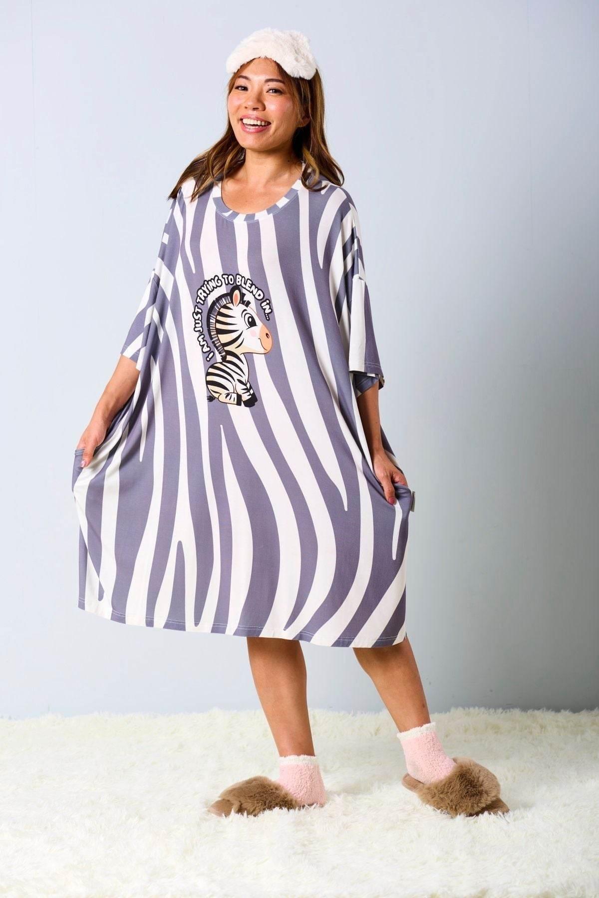 Woman wearing a striped sleep tee by MySleepTee with a zebra print design on a plain background