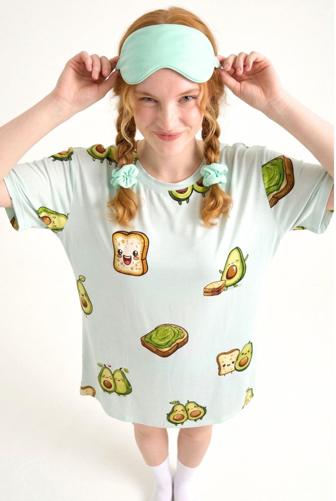 Woman wearing an Avo-Good Night mint sleep mask pushed up on her head with matching avocado toast print sleep tee
