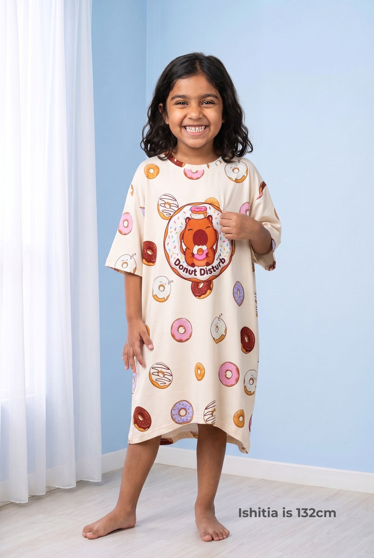 Young girl wearing the Donut Disturb Kids Mini Me bamboo sleep tee, an oversized nightdress-length tee falling below the knee.