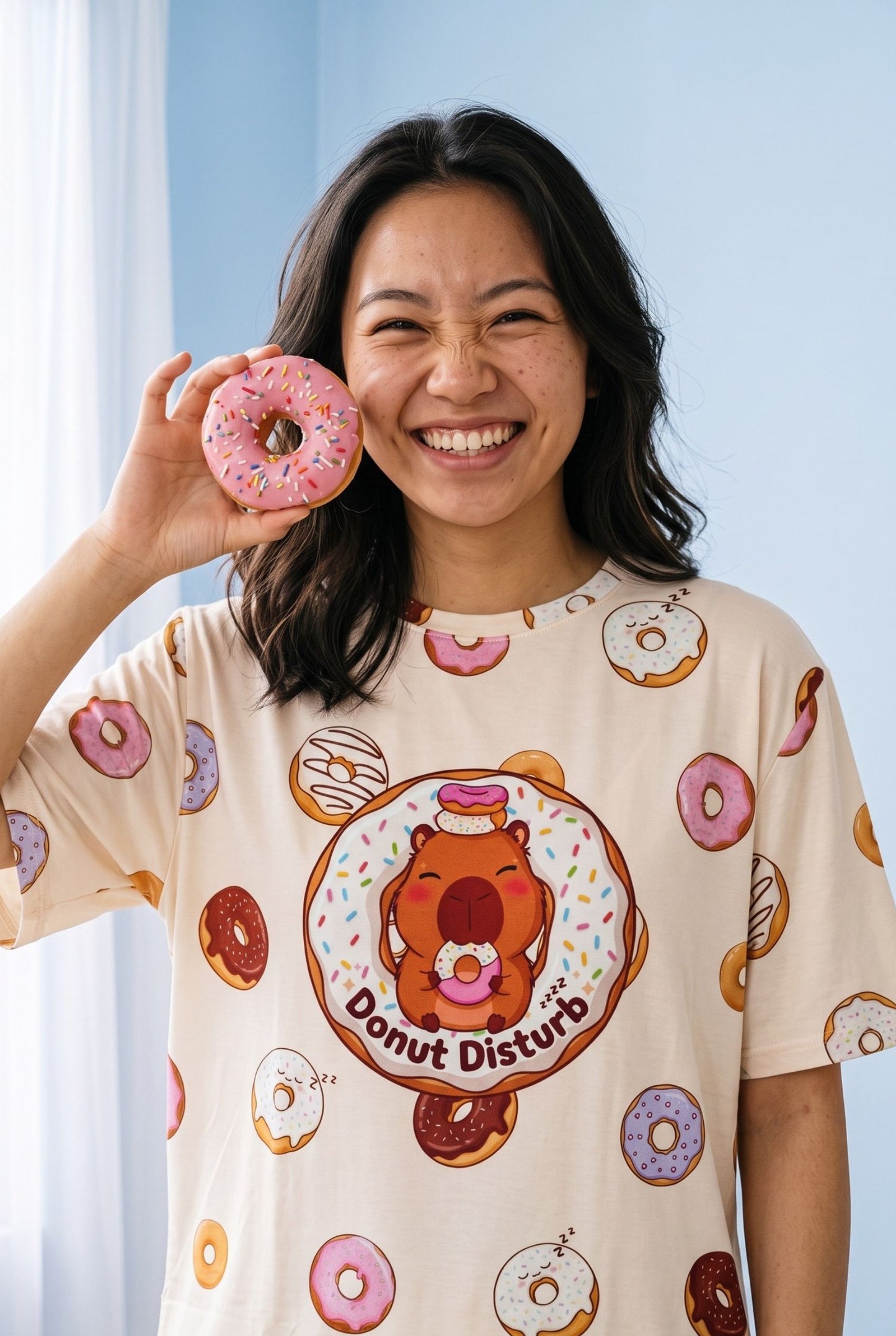 Close-up of the Donut Disturb print on the Petite sleep tee, showing the capybara design and scattered sleeping doughnuts on cream bamboo fabric.