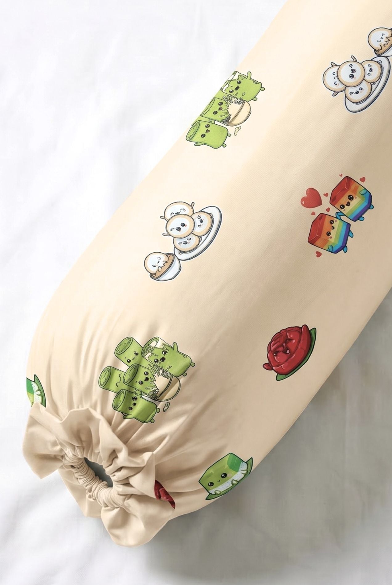 Close-up of Kueh-zy Medley bamboo bolster cover in cream kueh print showing the tie-end detail