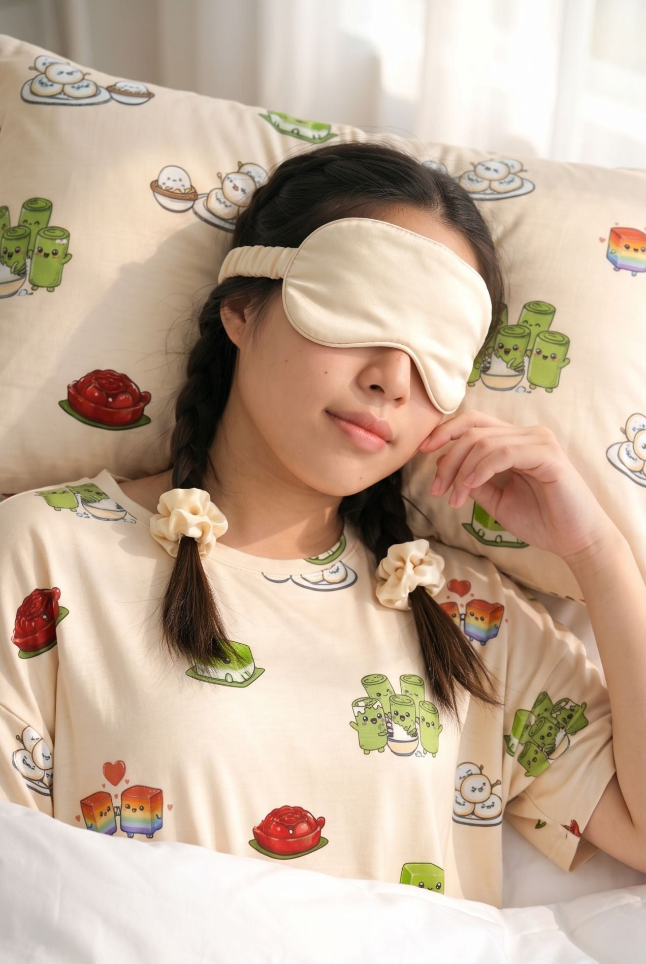 Woman asleep on a Kueh-zy Medley bamboo pillow wearing a matching cream sleep mask and kueh print sleep tee
