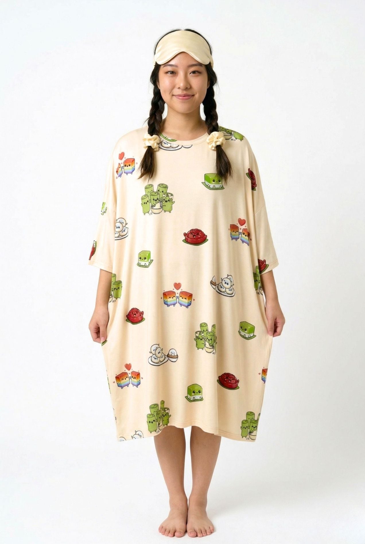 Woman wearing the Kueh-zy Medley cream kueh print sleep tee with a matching sleep mask and scrunchies