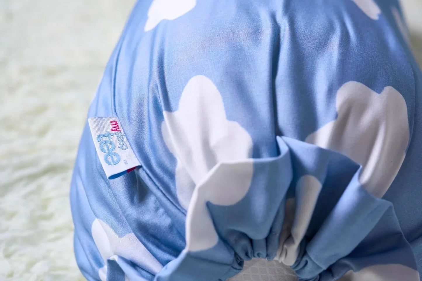 Blue bolster with white cloud patterns on a light background