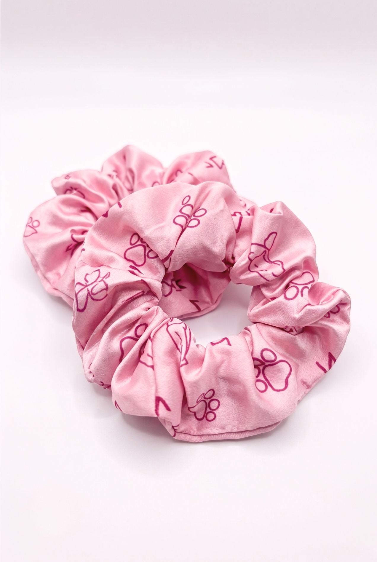 Paws & Snooze bamboo scrunchie set of 2 in pink cat and paw print, flat lay on white