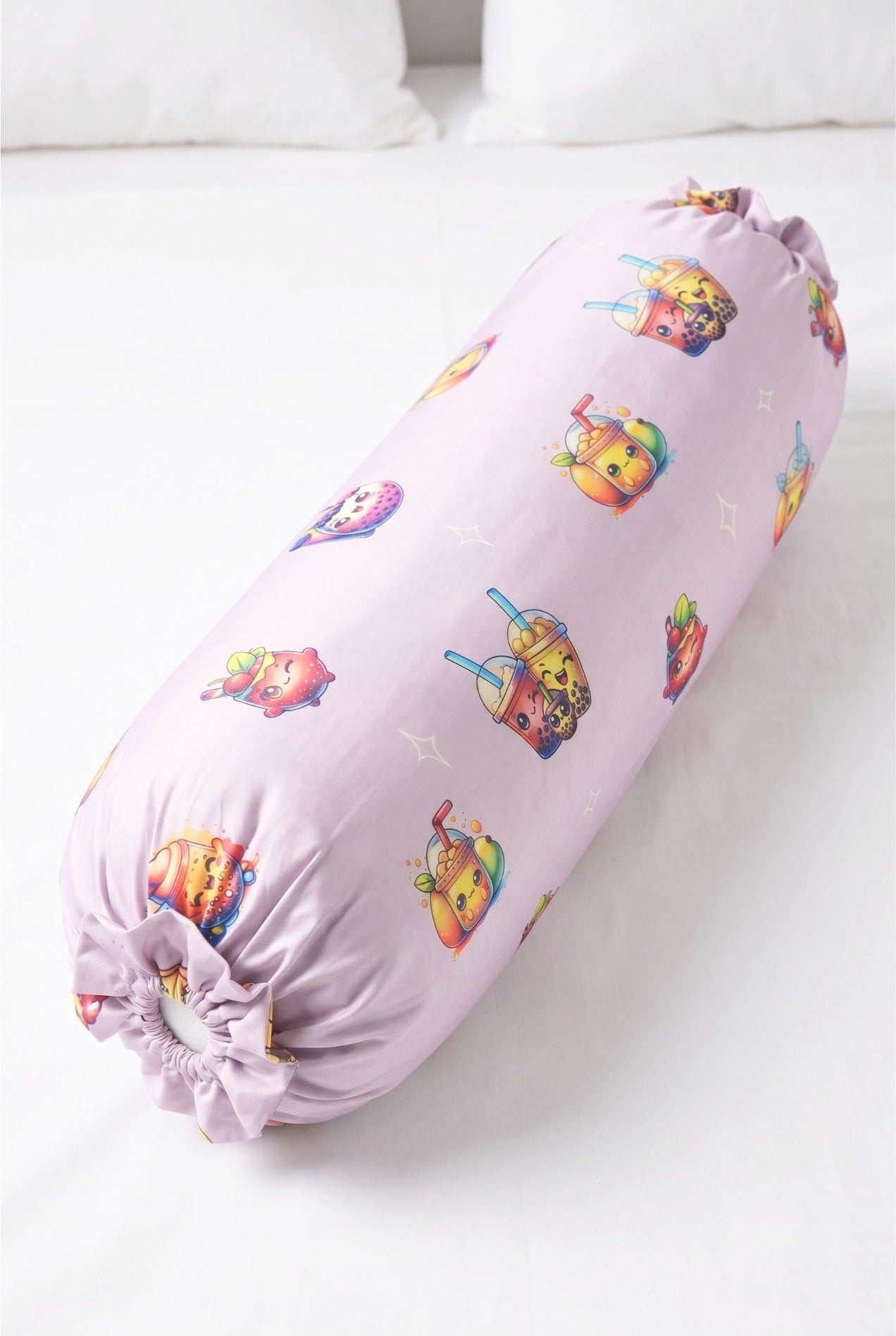 The Bubble Tee bamboo bolster cover in lilac bubble tea print, styled on a white bed