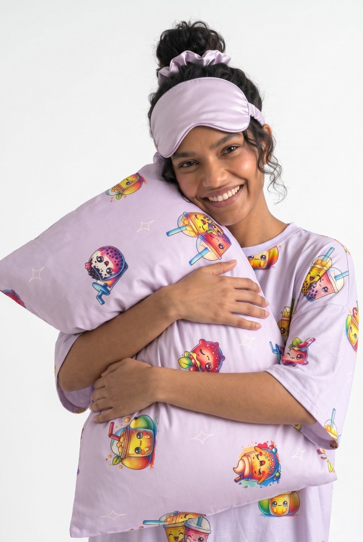 Woman in The Bubble Tee lilac bubble tea print sleep tee and matching sleep mask hugging a bamboo pillow