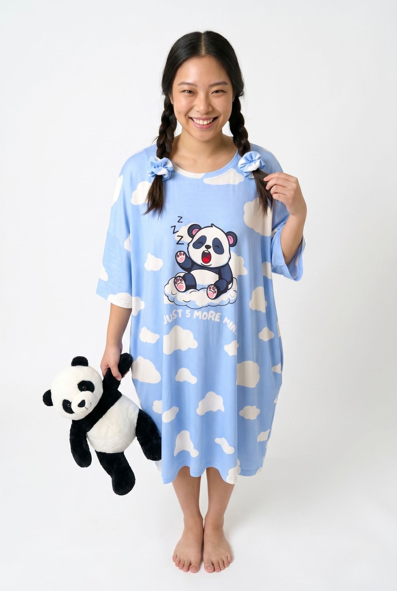 Woman in Un-bear-ably Sleepy bamboo scrunchies and matching cloud-print sleep tee holding a panda plush